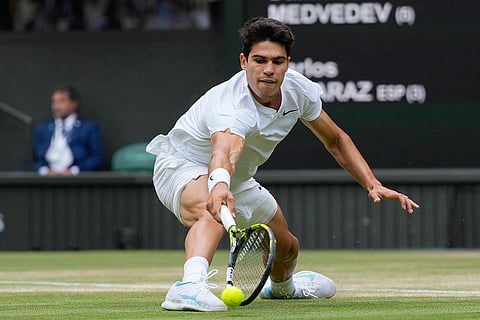 Carlos Alcaraz plays a backhand return to Daniil Medvedev